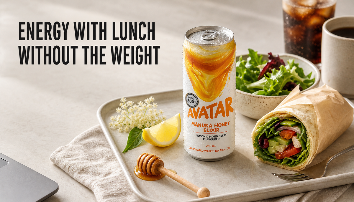 Chilled Avatar Elixir can beside a light desk lunch with lemon, honey, elderflower, salad, and sandwich, with coffee and soda set aside.