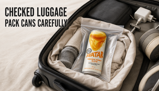 Open checked suitcase with an Avatar Elixir can sealed in a clear pouch and cushioned by clothing, with hard travel objects kept away and headline text about packing cans carefull...