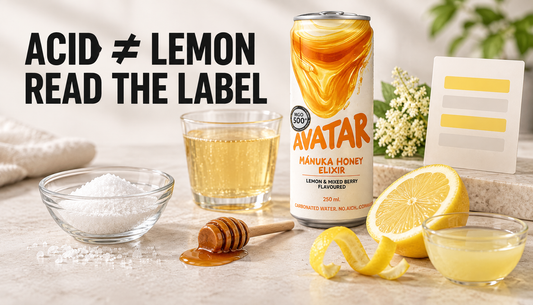 Avatar Elixir beside citric acid crystals, lemon peel, lemon juice, honey, and elderflower in an editorial comparison scene with the headline Acid ≠ Lemon, Read the Label.