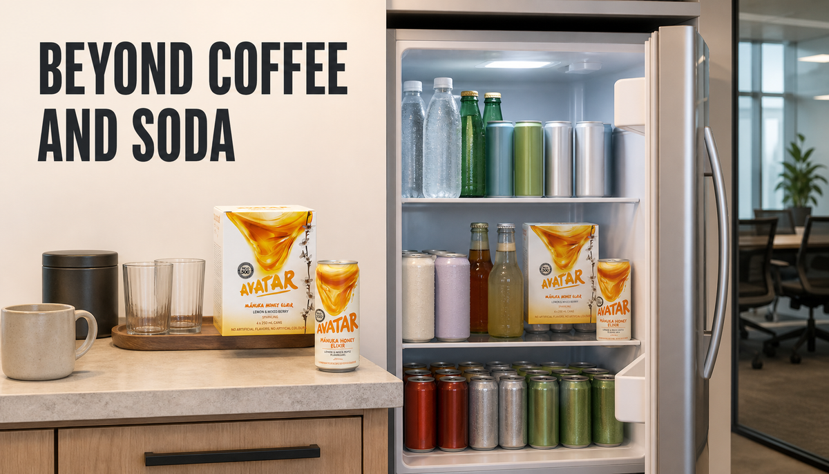 Open office drinks fridge stocked beyond coffee and soda with sparkling water, tea, mixers, and Avatar Manuka honey drinks for a workplace meeting room.