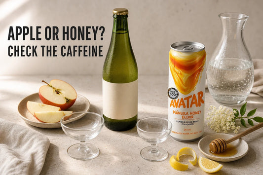 Small alcohol-free toast setup comparing a generic sparkling apple cider bottle with an Avatar Mānuka Honey Elixir can, with apple, honey, lemon, and elderflower cues.